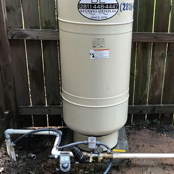 Tall beige outdoor pressure tank installed by B-E Waterwell Services in Magnolia TX